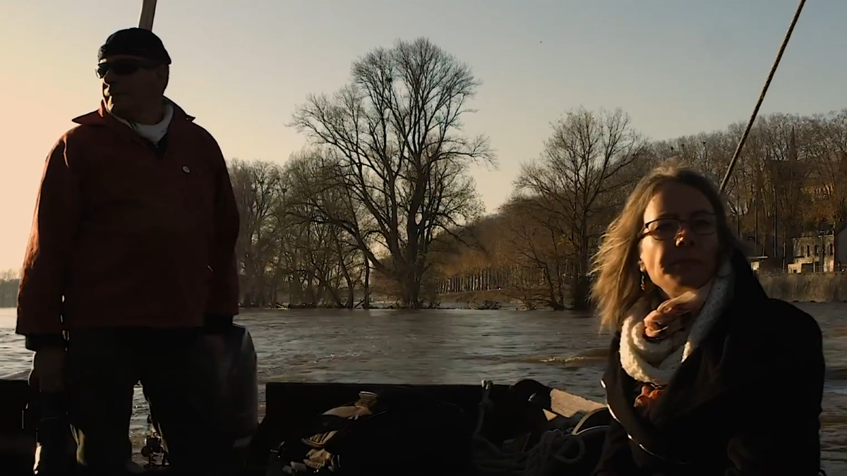 Un homme et une femme sur une gabare, naviguant sur la Loire au coucher du soleil