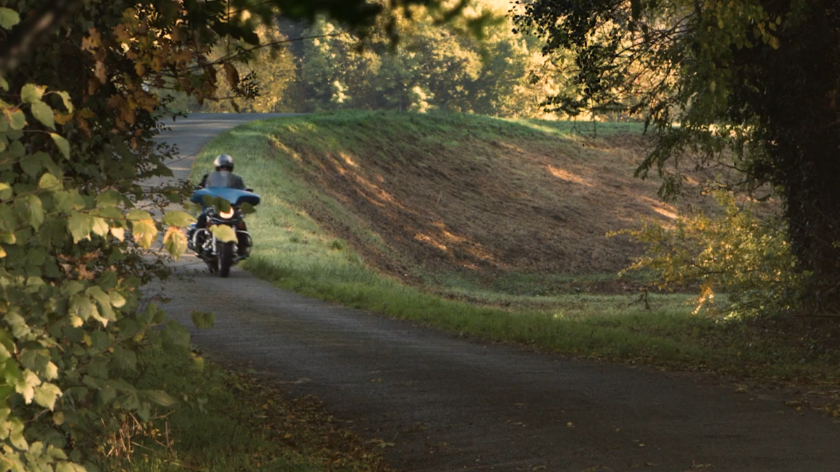 Motard roulant sur une route de campagne