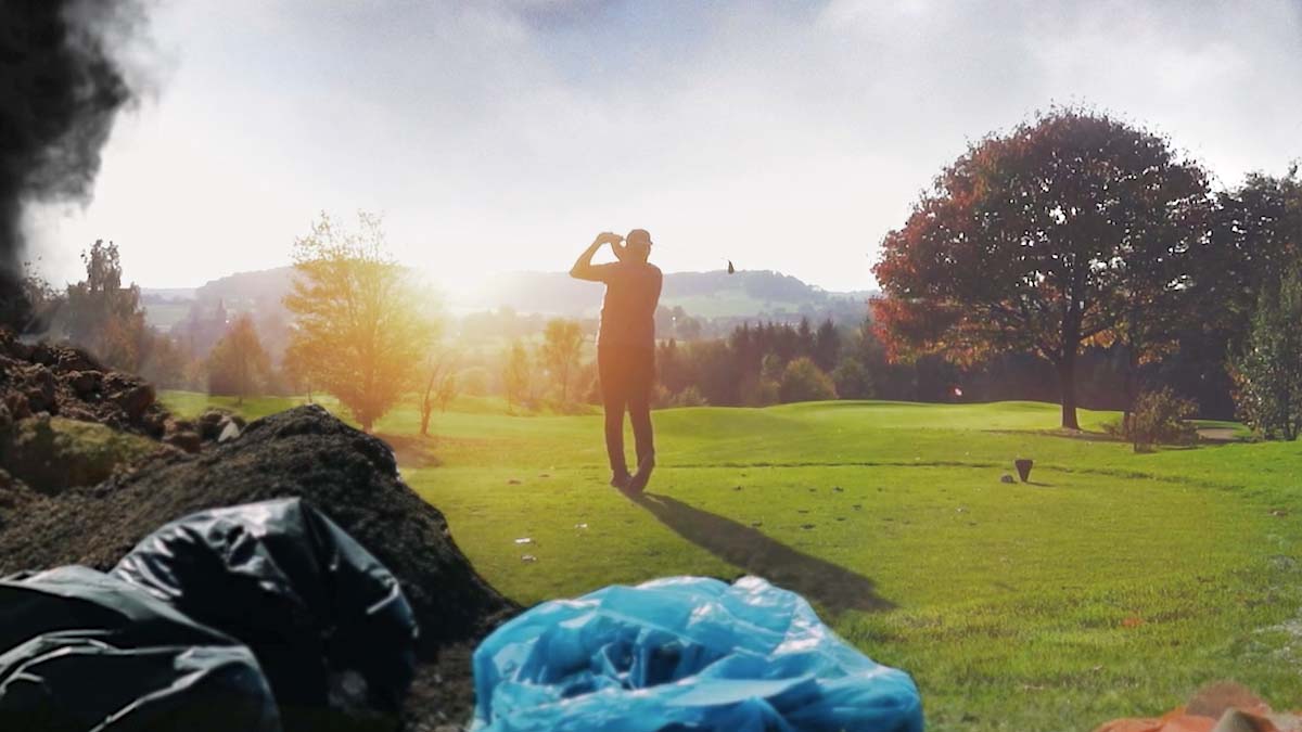 Golfeur en plein swing sur un green, sacs de déchets au premier plan