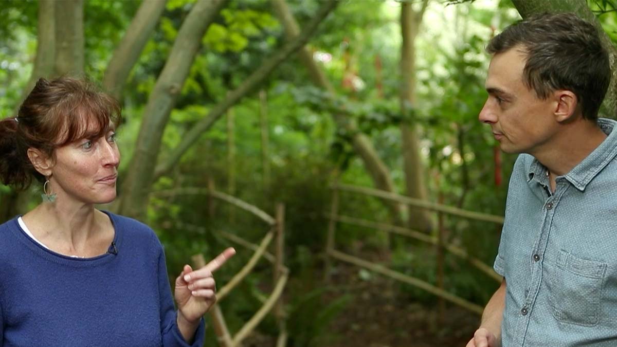 Deux personnes échangeant en pleine nature, au milieu d'un jardin boisé