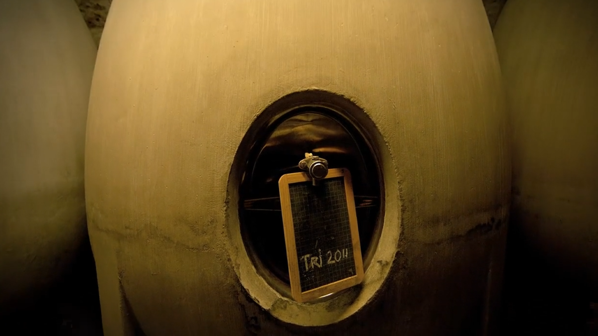 Gros plan sur une cuve à vin ovoïde avec une ardoise "Tri 2014"