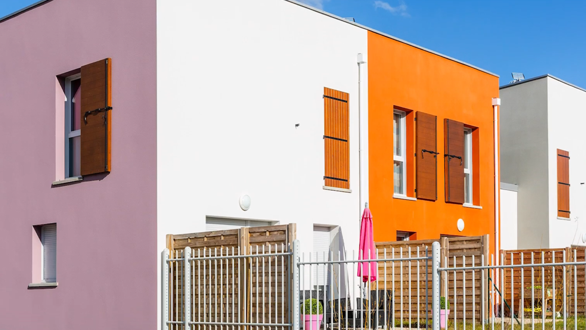 Façades colorées d'un programme immobilier résidentiel avec petits jardins clôturés