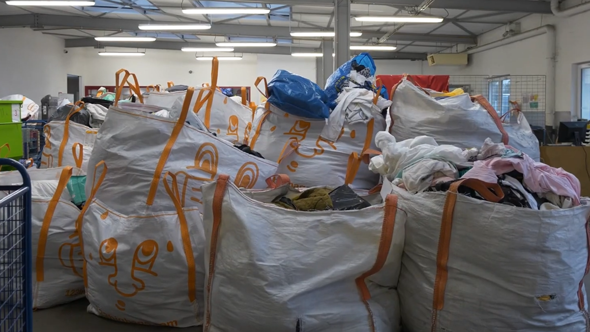 Big bags remplis de vêtements collectés pour le réemploi, dans un entrepôt