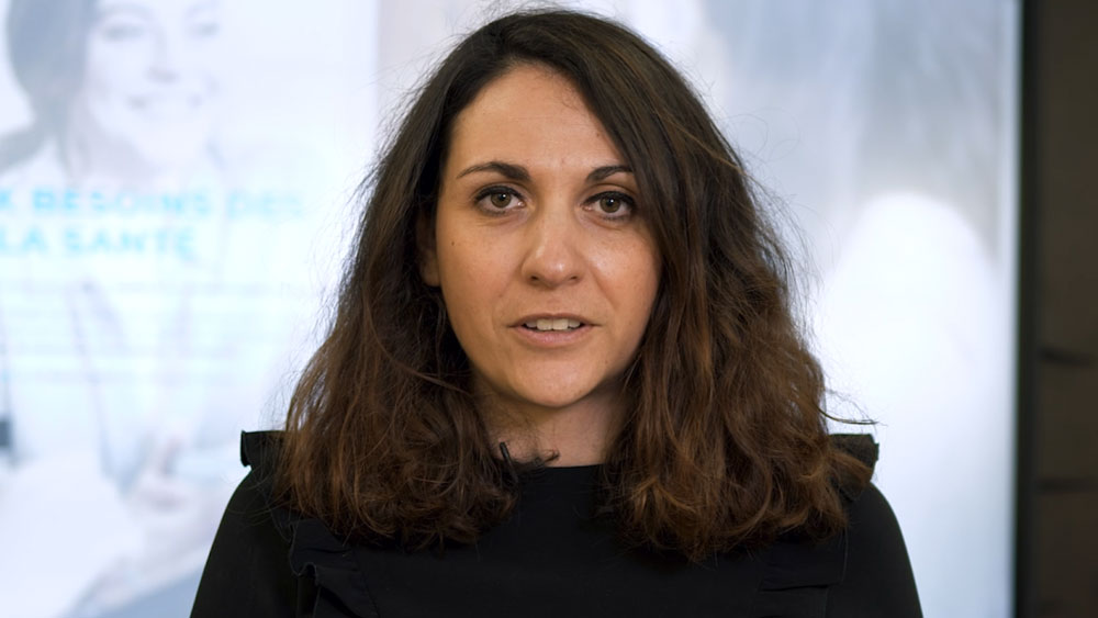 Portrait d'une femme s'exprimant face caméra, affiche liée à la santé en arrière-plan