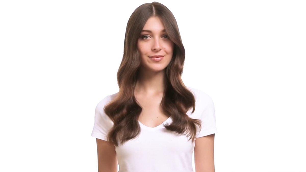 Portrait d'une femme aux cheveux longs et ondulés, sur fond blanc