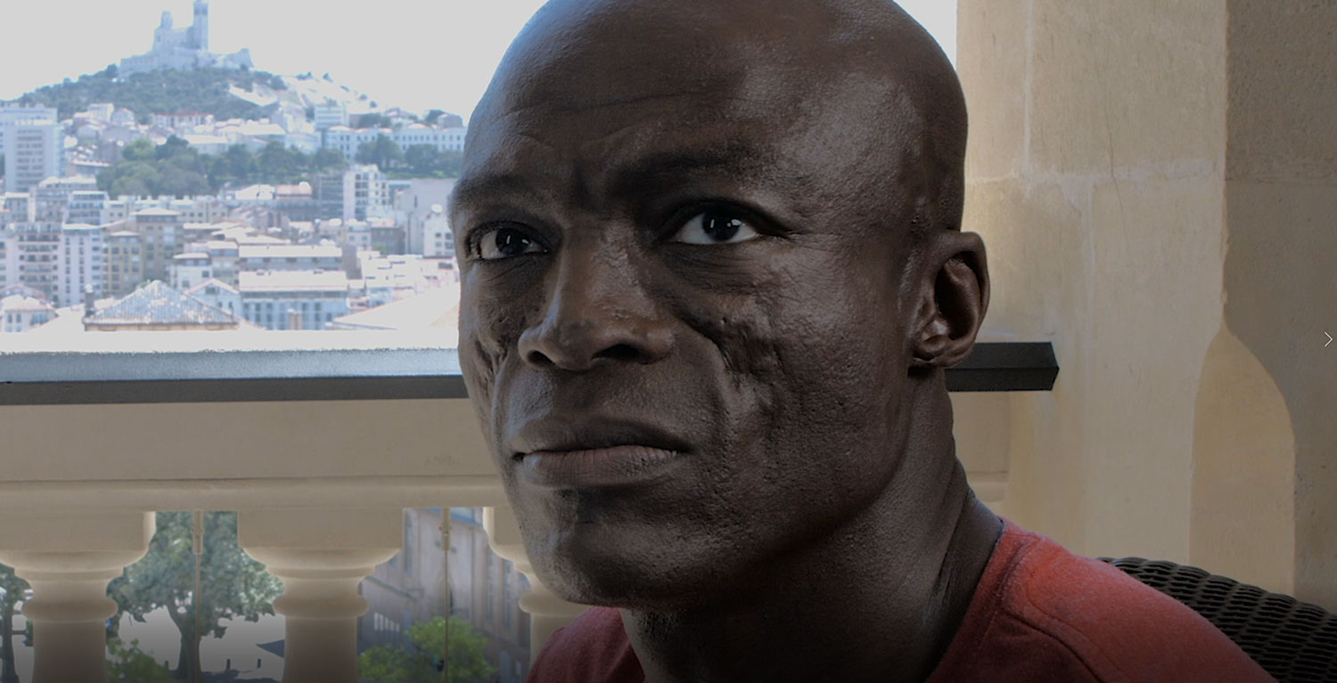 Portrait d'un homme sur un balcon avec vue sur la ville de Marseille