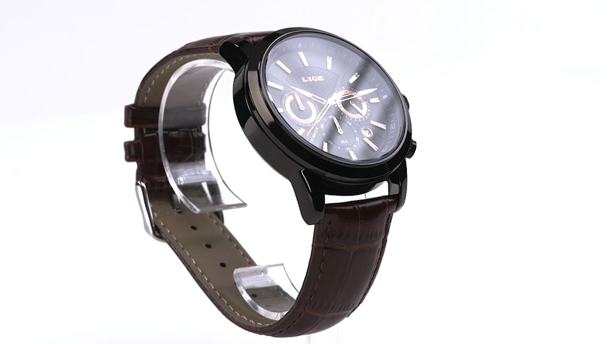 Montre chronographe LIGE à boîtier noir et bracelet en cuir marron, posée sur un support transparent